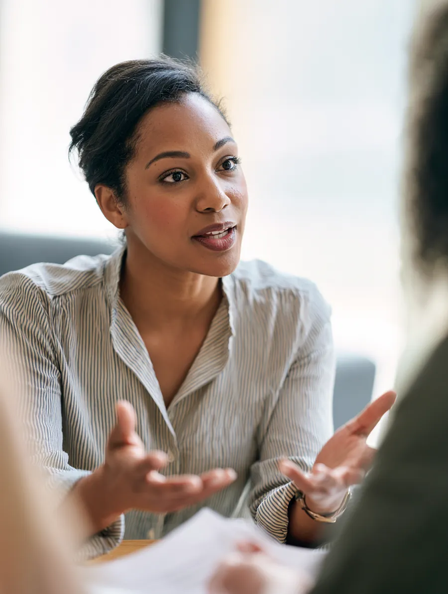 Loan advisor pointing at a printed document while explaining terms to a borrower
